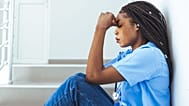 A health worker looks forlorn.