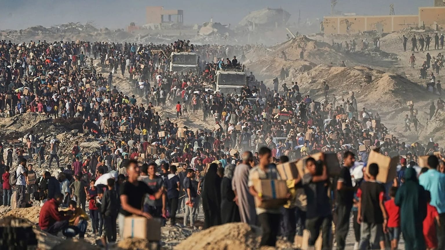 People carry humanitarian aid that was unloaded from a World Food Programme convoy in the northern Gaza Strip, 16 June, 2025