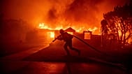 A firefighter battles the Palisades Fire as it burns a structure in the Pacific Palisades neighbourhood of Los Angeles, 7 January, 2025