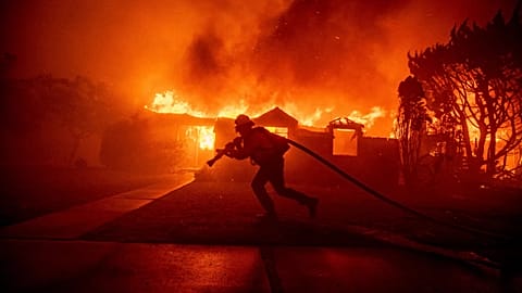 A firefighter battles the Palisades Fire as it burns a structure in the Pacific Palisades neighbourhood of Los Angeles, 7 January, 2025