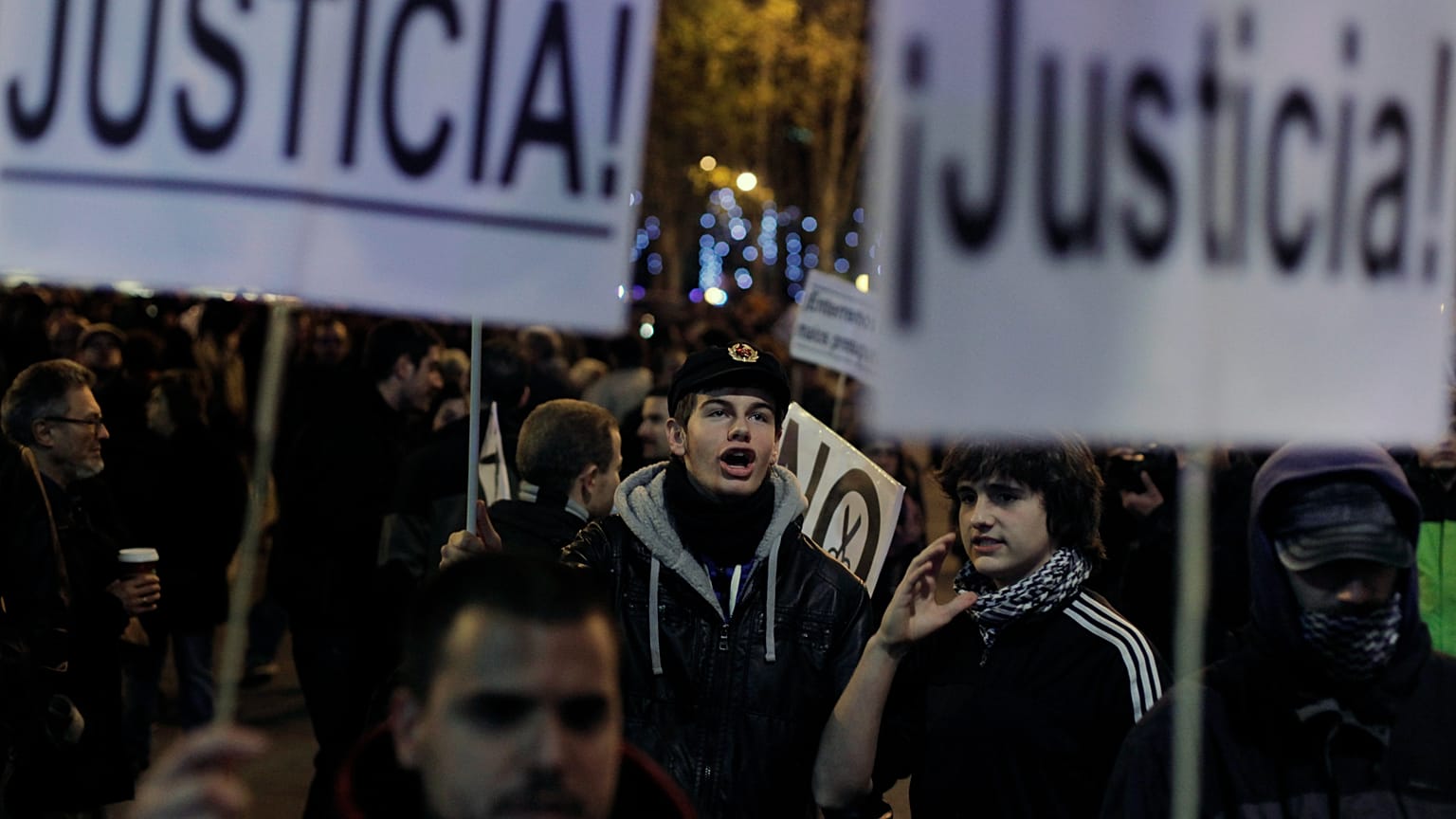 Protestors shout slogans as they hold banners reading 'Justice' during a demonstration against austerity measures and the approval of the budget for 2013 by the Spanish govern