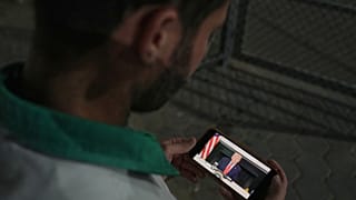 فلسطيني ينظر إلى هاتفه الذي يعرض صورة لترامب، بعد الإعلان عن اتفاق بين إسرائيل وحماس على المرحلة الأولى من خطة وقف القتال، الخميس 9 أكتوبر/تشرين الأول 2025. 
