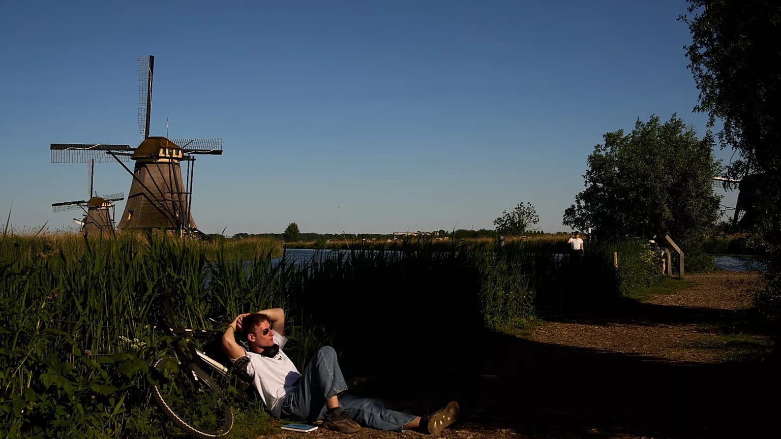 Une personne se repose à l'ombre près des moulins à vent du XVIIIe siècle. Photo de Lindsay Wasson