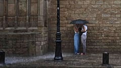 DATEI - Menschen suchen Schutz vor dem starken Regen (AP Photo/Emilio Morenatti)