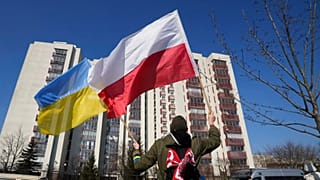 A man waves the Ukrainian and Polish flag during a demonstration in front of a building housing Russian diplomats in Warsaw, 13 March, 2022