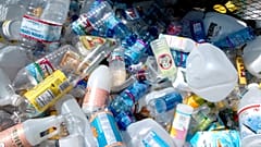 مجموعة من زجاجات البلاستيك داخل حاوية في مركز إعادة التدوير في بورتلاند، أوريغون