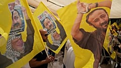 Des partisans du leader palestinien populaire Marwan Barghouti portent des drapeaux du Fatah à Ramallah, le 16 août 2025.