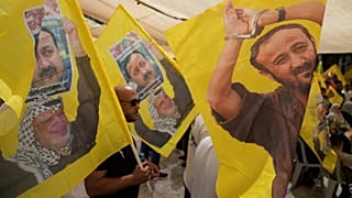 Apoiantes do líder popular palestiniano Marwan Barghouti carregam bandeiras da Fatah em Ramallah, 16 de agosto de 2025
