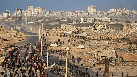 Carri armati israeliani sono posizionati sulla strada costiera che porta a Gaza City mentre i palestinesi sfollati si riuniscono vicino a Wadi Gaza, nella Striscia di Gaza centrale, giovedì 9 ottobre 2025.