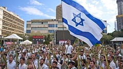 In Gebetsschals gehüllt, tanzen und beten Männer in Tel Aviv.