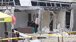 يقف السكان بجوار منزل متضرر بعد زلزال قوي في مدينة دافاو، جنوب الفلبين، يوم الجمعة 10 أكتوبر/تشرين الأول 2025.