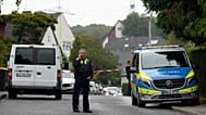 Ein Polizist telefoniert am 7. Oktober 2025, auf einer Straße in Herdecke, nachdem die neu gewählte Bürgermeisterin Iris Stalzer schwer verletzt  in ihrem Haus gefunden wurde.