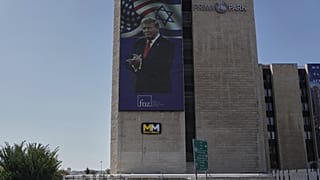 Persone passano davanti a un grande schermo all'aperto che mostra un'immagine del Presidente degli Stati Uniti Donald Trump, a Gerusalemme, sabato 11 ottobre 2025, dopo che Israele e Hamas hanno concordato un accordo di pace. 