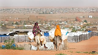 امرأتان سودانيتان نازحتان تحملان إمدادات المياه في مخيم السلام للاجئين بالقرب من بلدة الفاشر بدارفور، السودان