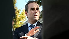 O primeiro-ministro francês reconduzido, Sebastien Lecornu, fala com jornalistas enquanto visita uma esquadra de polícia em L'Hay-les-Roses, nos arredores de Paris, sábado, 11 de outubro de 2025. (Martin L