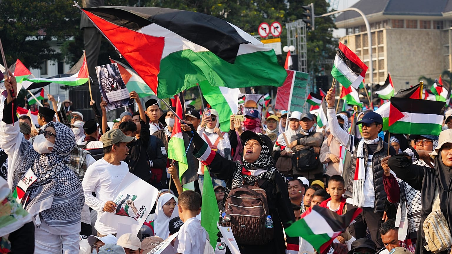 يرفع المتظاهرون الأعلام الفلسطينية خلال تجمع تضامني مع الفلسطينيين في غزة