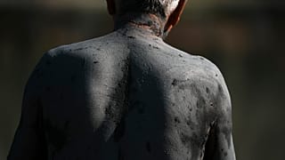 رجل يستمتع بحمام طين يُعتقد أنه يعالج أمراضًا مثل التهاب المفاصل ومفيد للبشرة في منتجع بورتو رافتي الساحلي،شرق أثينا يوم الثلاثاء 19 أغسطس 2025. 