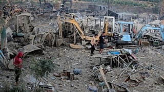 يتجمع الناس في موقع لبيع المعدات الثقيلة، حيث تم تدمير عدد كبير من المركبات في الغارات الجوية الإسرائيلية، في قرية المصيلح الجنوبية، لبنان، السبت 11 أكتوبر/تشرين الأول 2025.