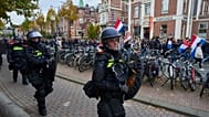 Dutch riot police escort anti-immigration protesters during a demonstration in Amsterdam, Netherlands, Sunday, Oct. 12, 2025.
