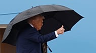 President Donald Trump gestures from the stairs of Air Force One as he boards