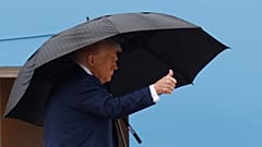 Präsident Donald Trump gestikuliert auf der Treppe der Air Force One, während er an Bord geht