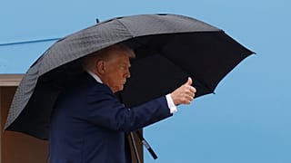 Präsident Donald Trump gestikuliert auf der Treppe der Air Force One, während er an Bord geht