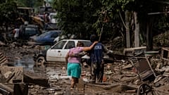 Ein Marine hilft einer Frau beim Überqueren einer überfluteten Straße in Poza Rica, Veracruz, Mexiko, Sonntag, 12. Oktober 2025.