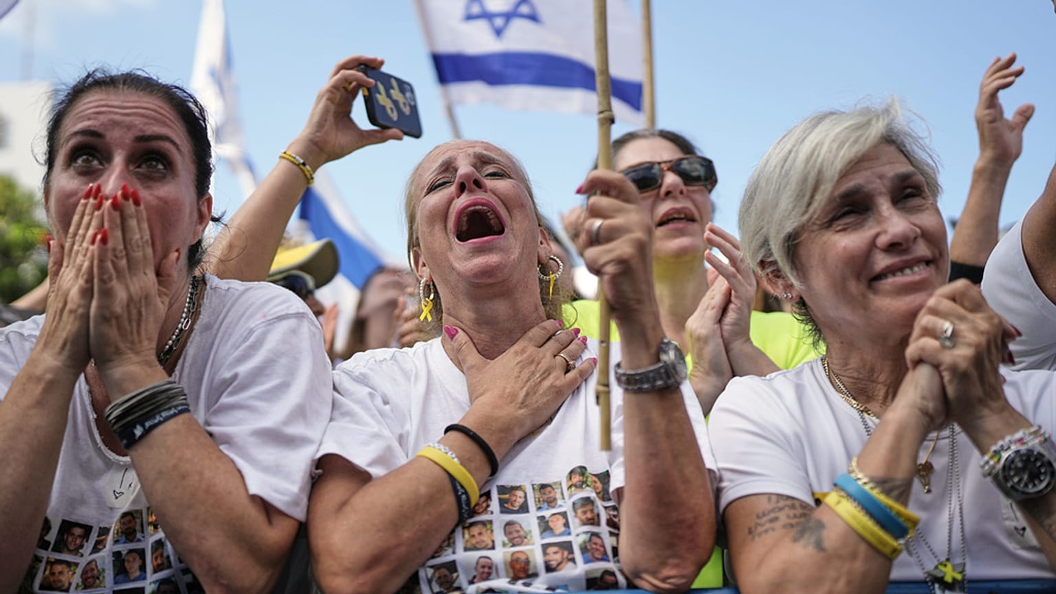Les gens réagissent alors qu'ils se rassemblent pour regarder la retransmission en direct de la libération des otages israéliens à Gaza