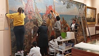Les restaurateurs à l'œuvre sur la peinture souillée