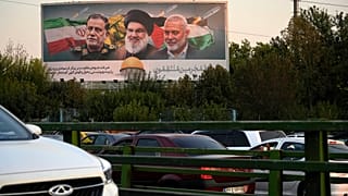 صورة تظهر زعماء حزب الله وحماس والحرس الثوري الإيراني على لوحة إعلانية في طهران في 7 أكتوبر 2024