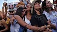 People react as they gather to watch a live broadcast of Israeli hostages released from Gaza at a plaza known as hostages square in Tel Aviv, Israel, Monday, Oct. 13, 2025