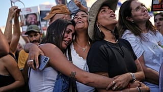 People react as they gather to watch a live broadcast of Israeli hostages released from Gaza at a plaza known as hostages square in Tel Aviv, Israel, Monday, Oct. 13, 2025