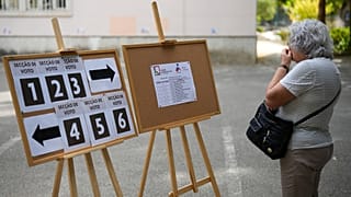 ARQUIVO (12/10/2025): Uma mulher verifica onde votar numa secção eleitoral para as eleições municipais de Portugal, em Lisboa.