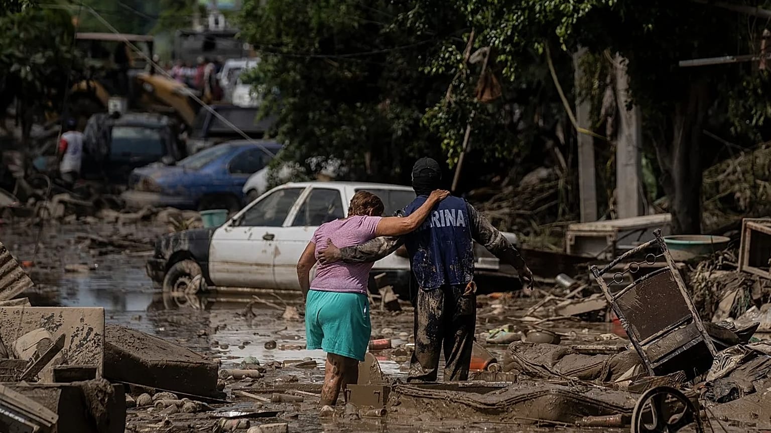 Um fuzileiro naval ajuda uma mulher a atravessar uma rua inundada em Poza Rica, Veracruz, México, no domingo, 12 de outubro de 2025
