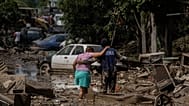 Um fuzileiro naval ajuda uma mulher a atravessar uma rua inundada em Poza Rica, Veracruz, México, no domingo, 12 de outubro de 2025
