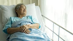 Eine Frau im Krankenhaus schaut aus dem Fenster.