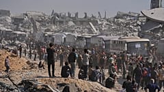 Des bus transportant des prisonniers palestiniens libérés passent devant des bâtiments détruits dans la bande de Gaza à Khan Younès, le lundi 13 octobre 2025.