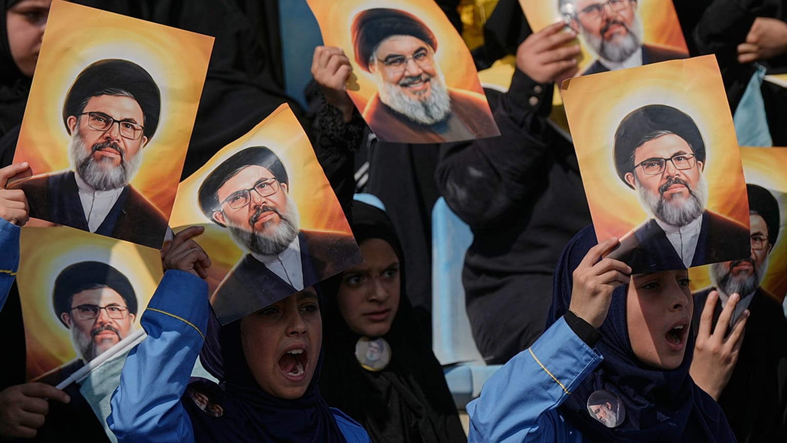 Beyrut'ta, Hizbullah'ın eski lideri Hasan Nasrallah'ın fotoğrafının yer aldığı posterleri tutan insanlar, 12 Ekim 2025