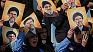 Beyrut'ta, Hizbullah'ın eski lideri Hasan Nasrallah'ın fotoğrafının yer aldığı posterleri tutan insanlar, 12 Ekim 2025