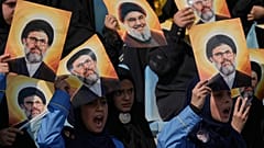 Beyrut'ta, Hizbullah'ın eski lideri Hasan Nasrallah'ın fotoğrafının yer aldığı posterleri tutan insanlar, 12 Ekim 2025