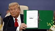 ABD Başkanı Donald Trump, Mısır'ın Şarm El-Şeyh kentinde imzaladığı belgeyi kameralara gösterirken, 13 Ekim 2025