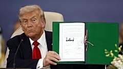 ABD Başkanı Donald Trump, Mısır'ın Şarm El-Şeyh kentinde imzaladığı belgeyi kameralara gösterirken, 13 Ekim 2025
