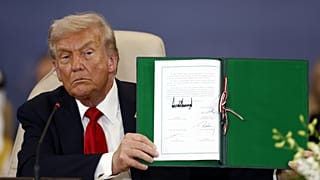 ABD Başkanı Donald Trump, Mısır'ın Şarm El-Şeyh kentinde imzaladığı belgeyi kameralara gösterirken, 13 Ekim 2025