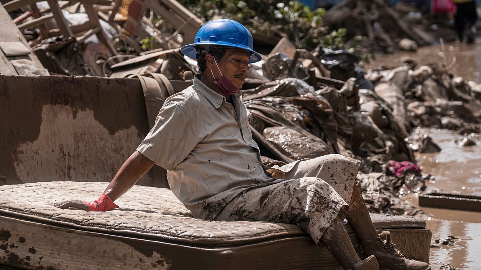 Un hombre que limpia casas inundadas se toma un descanso en Poza Rica, Veracruz, México, el 12 de octubre de 2025.