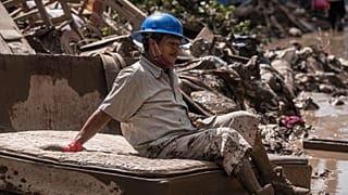 Un hombre que limpia casas inundadas se toma un descanso en Poza Rica, Veracruz, México, el 12 de octubre de 2025.