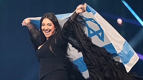 FILE - Singer Yuval Raphael waves Israel's national flag during a dress rehearsal for the 69th Eurovision Song Contest, in Basel, Switzerland, 16 May, 2025