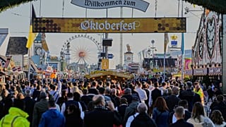 Visitors walk to the re-opening of the Oktoberfest that was closed since the morning after a bomb threatening in Munich, Germany, Wednesday, Oct.1, 2025.
