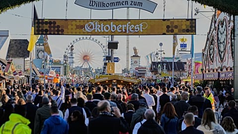 Visitors walk to the re-opening of the Oktoberfest that was closed since the morning after a bomb threatening in Munich, Germany, Wednesday, Oct.1, 2025.