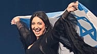 ARCHIVO - El cantante Yuval Raphael ondea la bandera nacional de Israel durante un ensayo general para el 69º Festival de Eurovisión, en Basilea, Suiza, 16 de mayo de 2025.