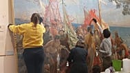 Un grupo de profesionales trabaja en la restauración del cuadro 'Primer homenaje a Cristóbal Colón', de José Garnelo.